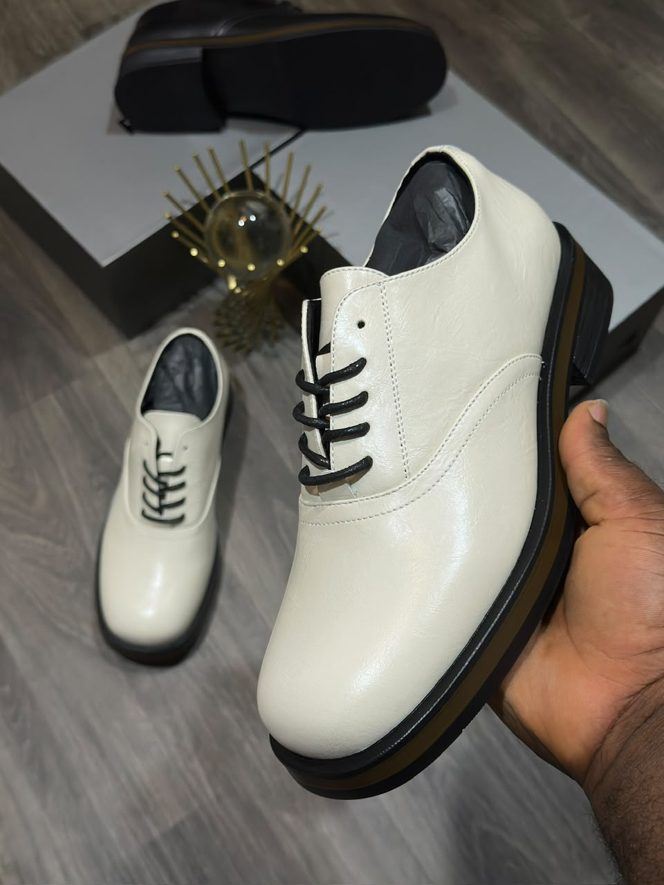 Men's luxury leather oxford shoe Men's luxury black leather oxford dress shoes with a thick sole and tan midsole accent resting on a marble surface.