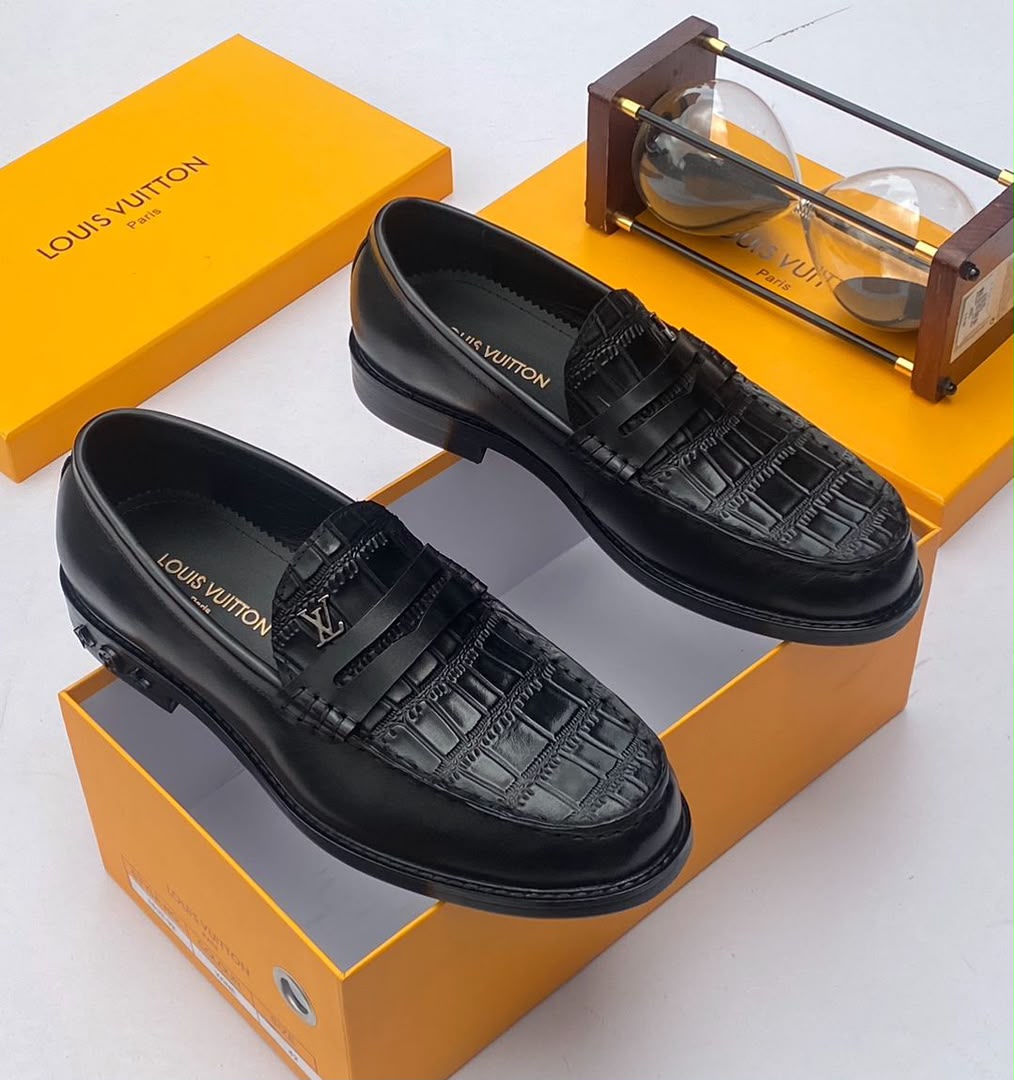 Louis Vuitton chocolate brown croc-embossed penny loafers Men's chocolate brown Louis Vuitton crocodile-embossed penny loafers with metal LV hardware and rubber-injected heel, displayed with branded orange shoebox and hourglass on white surface.