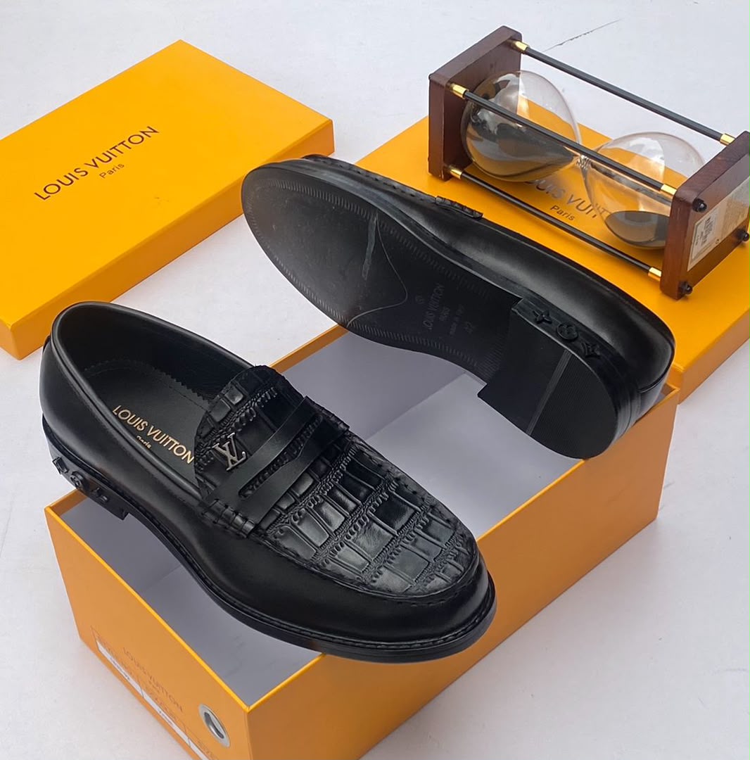 Louis Vuitton chocolate brown croc-embossed penny loafers Men's chocolate brown Louis Vuitton crocodile-embossed penny loafers with metal LV hardware and rubber-injected heel, displayed with branded orange shoebox and hourglass on white surface.
