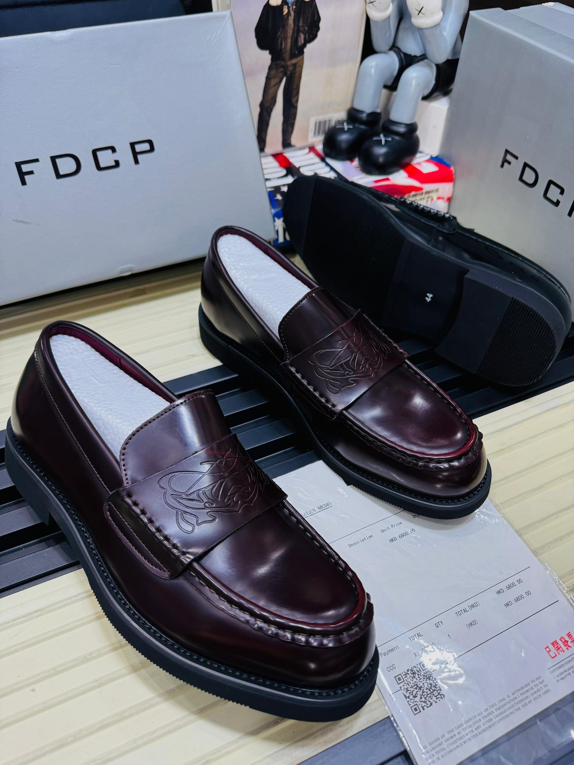 Premium FDCP leather loafers FDCP men's burgundy high-gloss leather loafers with embossed strap detail and thick black rubber sole, displayed with branded grey shoebox and sales receipt.