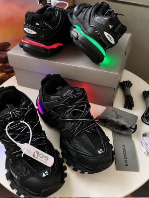 Men's luxury black Balenciaga Track sneakers with blue and red neon sole accents, extra laces, and grey branded box.