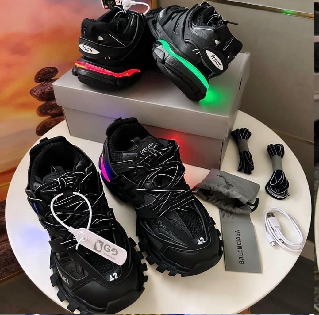 Iconic Balenciaga Track sneakers Men's luxury black Balenciaga Track sneakers with blue and red neon sole accents, extra laces, and grey branded box.