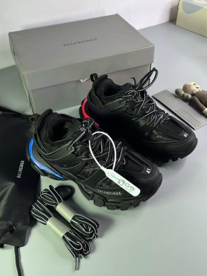 Men's luxury black Balenciaga Track sneakers with blue and red neon sole accents, extra laces, and grey branded box.