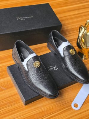 Men's luxury black crocodile-embossed leather loafers with gold medallion hardware resting on black Richwanaz shoeboxes.