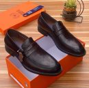 Franco Binetti men's dark brown leather brogue loafers with penny strap and medallion toe detail, displayed in orange branded shoebox on wooden surface.