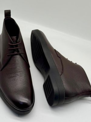 Bally men's dark brown pebbled leather chukka boots with tonal laces and black rubber sole, displayed on white background showing side profile and sole detail.