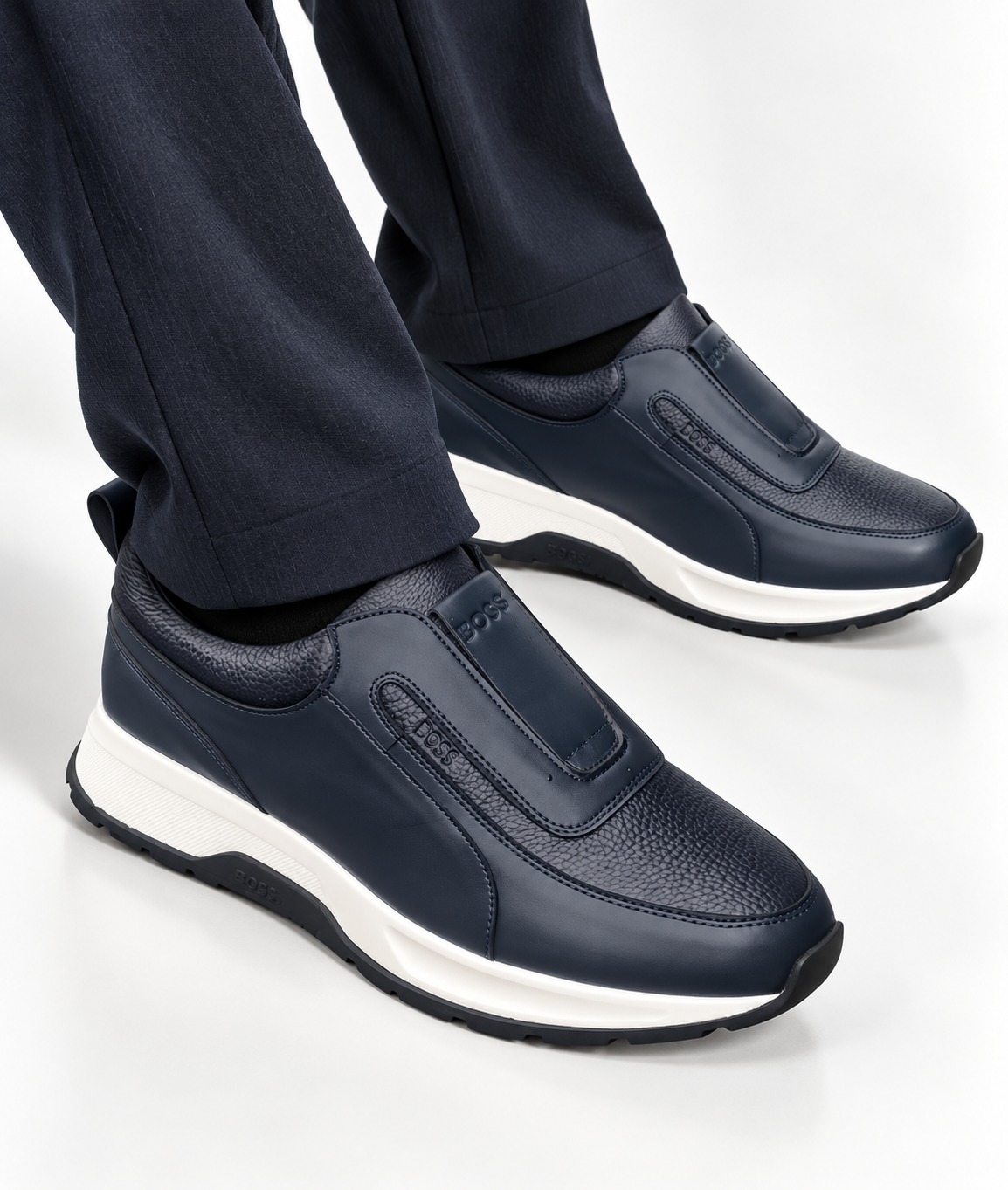 Navy men's leather Hugo Boss slip-on sneakers with white rubber sole and elastic strap.