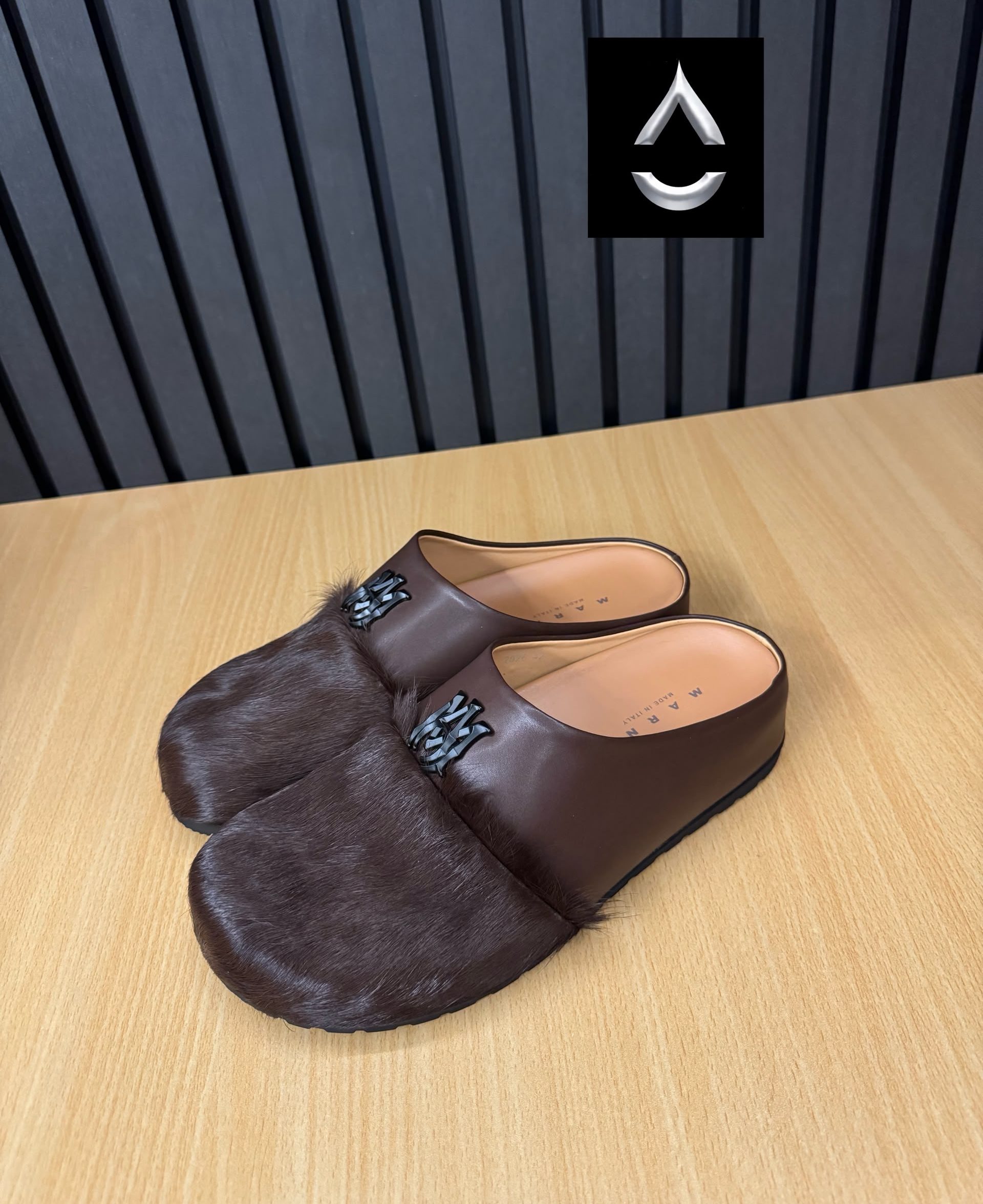 Iconic AMIRI fur-detailed slide mules AMIRI luxury fur slide mules in white, black, and brown with authentic leather upper, plush fur detailing, signature AM logo, and cushioned sole displayed with original black AMIRI box