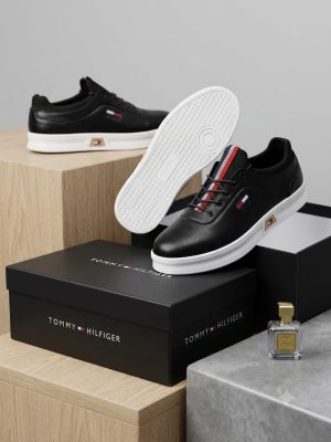 Navy men's leather Tommy Hilfiger sneakers with red and white striped detailing and white rubber sole.