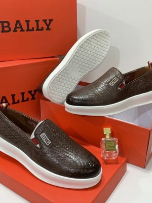 Dark brown men's woven leather Bally slip-on shoes with white rubber sole and metallic logo plaque.